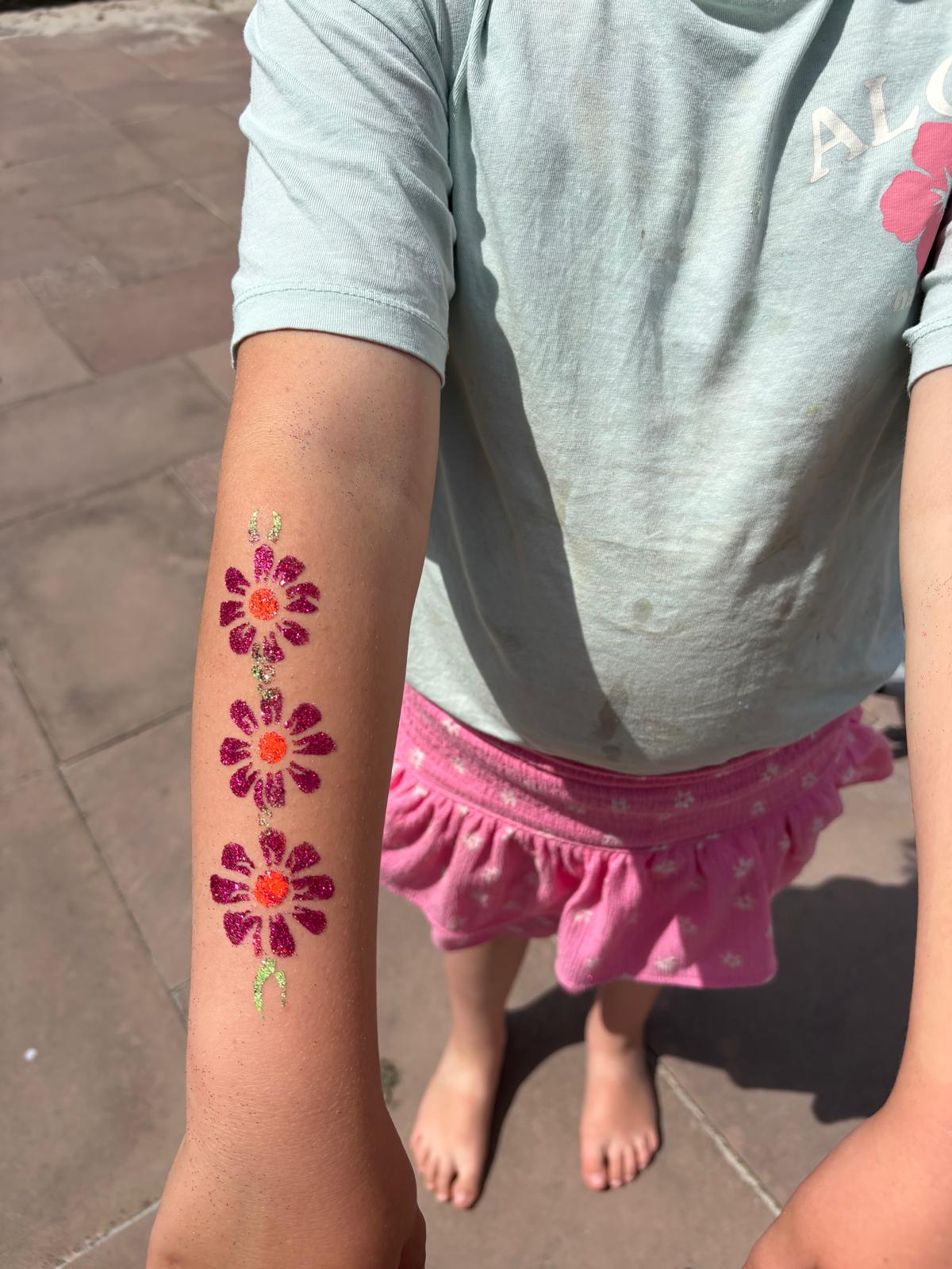 Paarse glitterbloemen op een arm tijdens een kinderfeestje