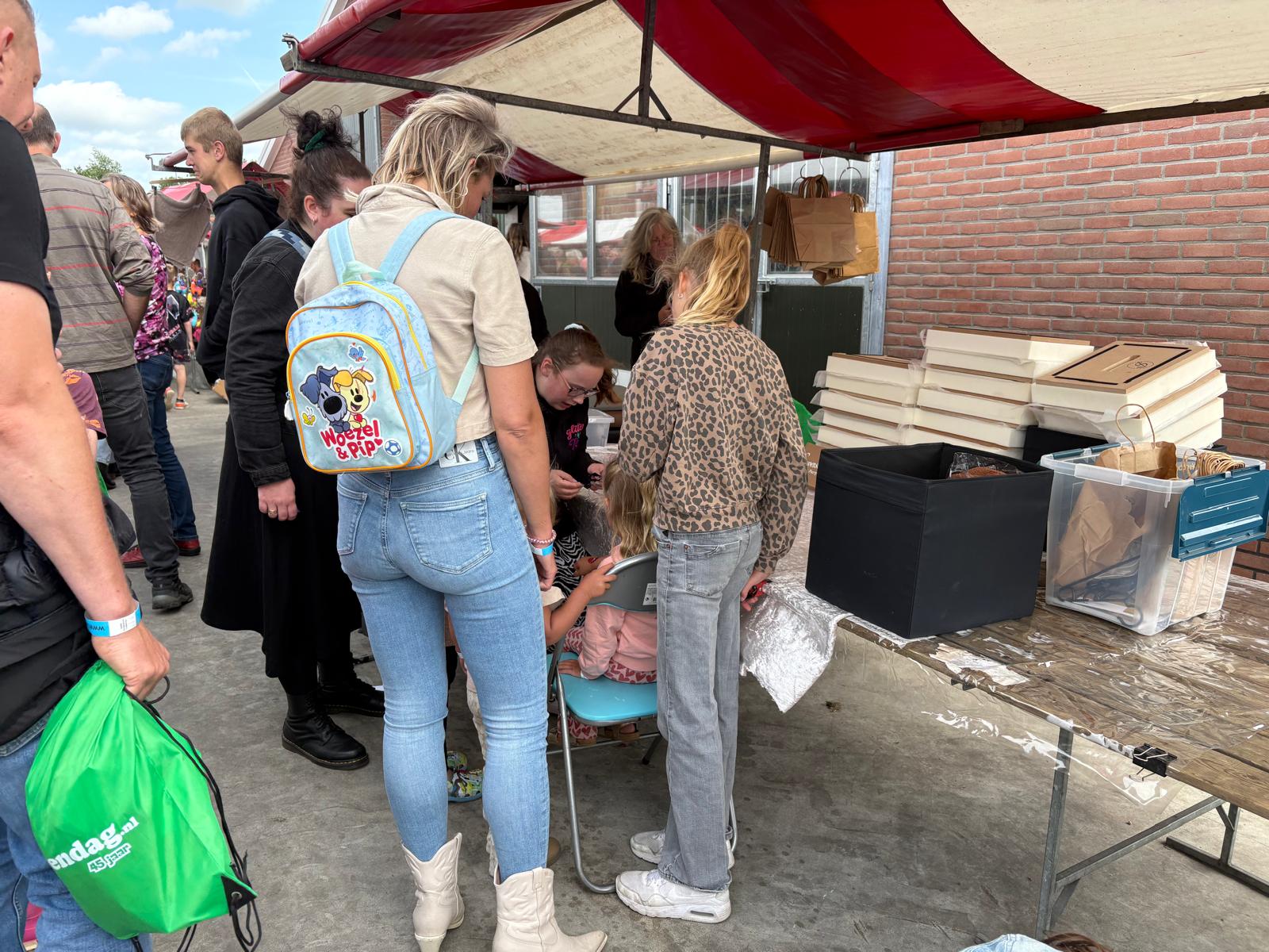 Kinderen en ouders bij glittertattoos op de Boerendag