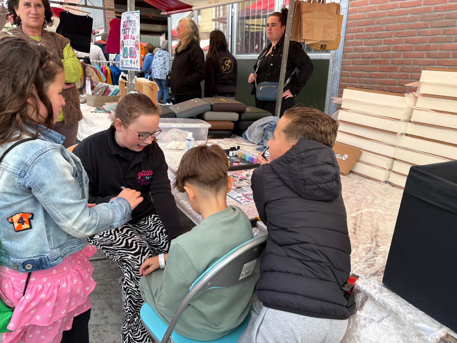Tess zet glittertattoos op de Boerendag in Hekendorp